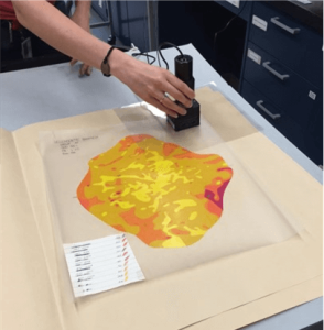 Scientist using a handheld FTIR attachment to identify the plastic used to print this topographical map of a section of the moon